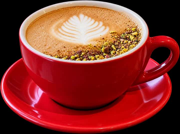 Hot latte with rosetta latte art in a red cup and saucer